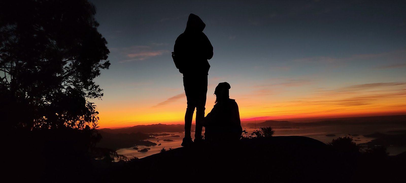 Visitantes em silhueta contemplando o amanhecer na Pedra da Macela