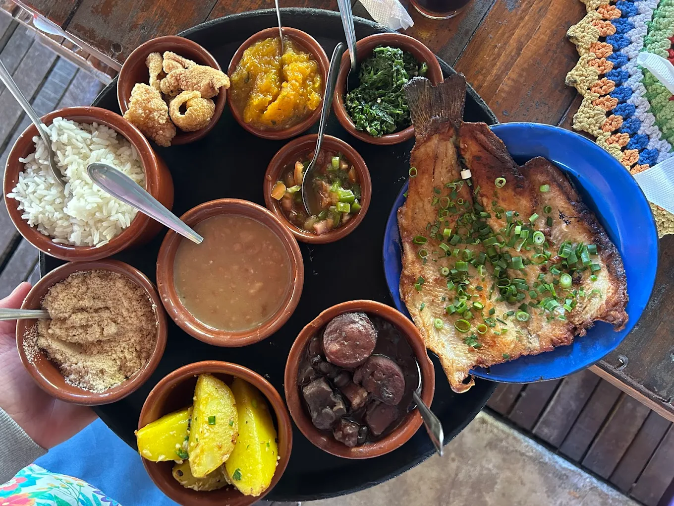 Prato caseiro servido no Quintal da Cau com peixe, feijão, arroz, farofa e acompanhamentos