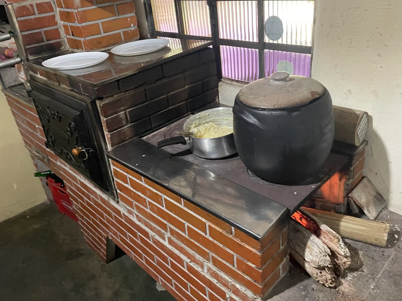 Fogão a lenha aceso preparando comida caseira no Quintal da Cau